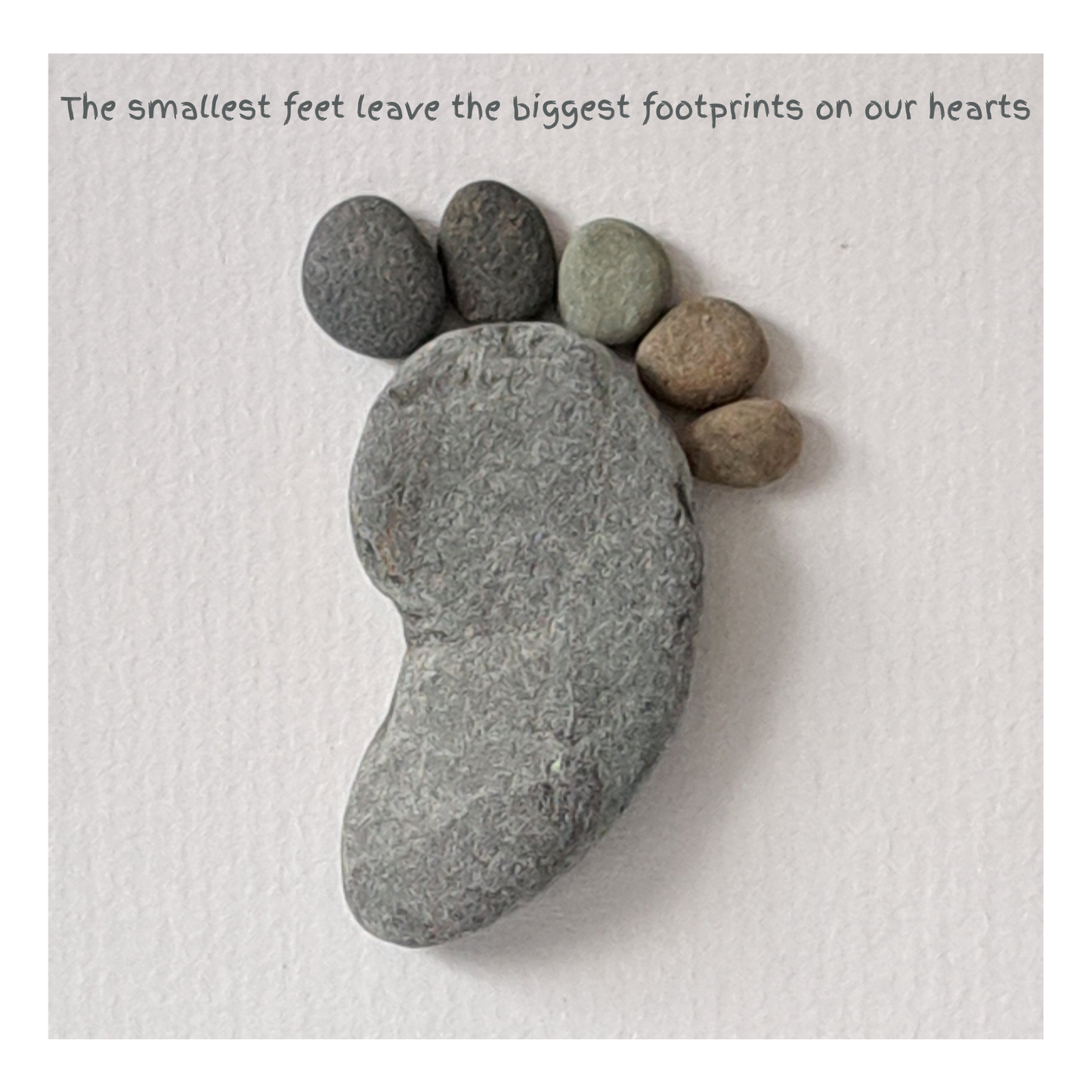 Footprint-shaped stones on a textured surface with a motivational quote.