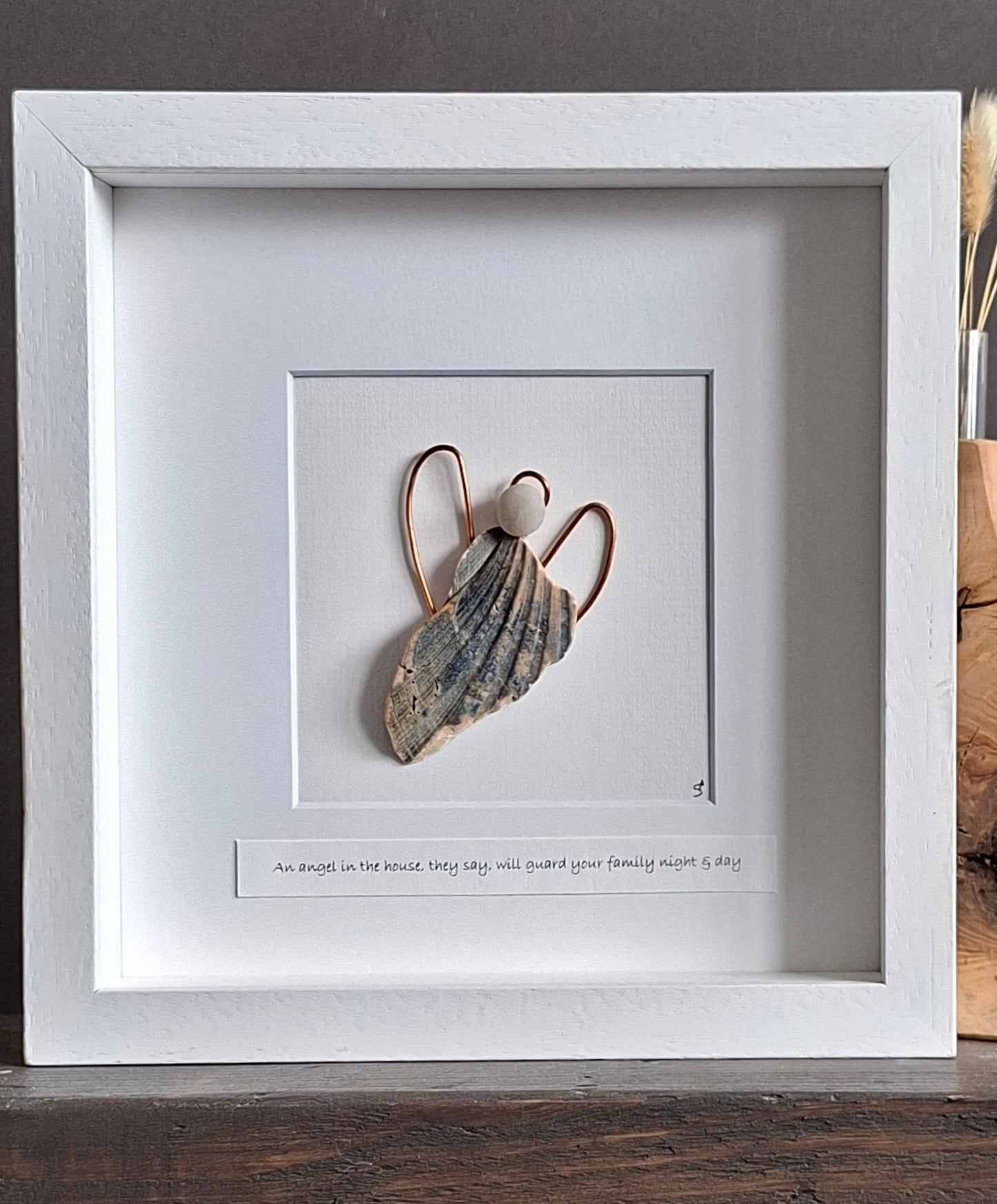 A guardian angel created from a natually shaped shell and beach pebble with copper wings